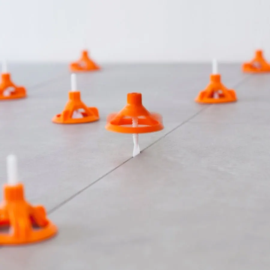 Tebo Spin Level med orange nivåhattar mellan grå plattor under läggning